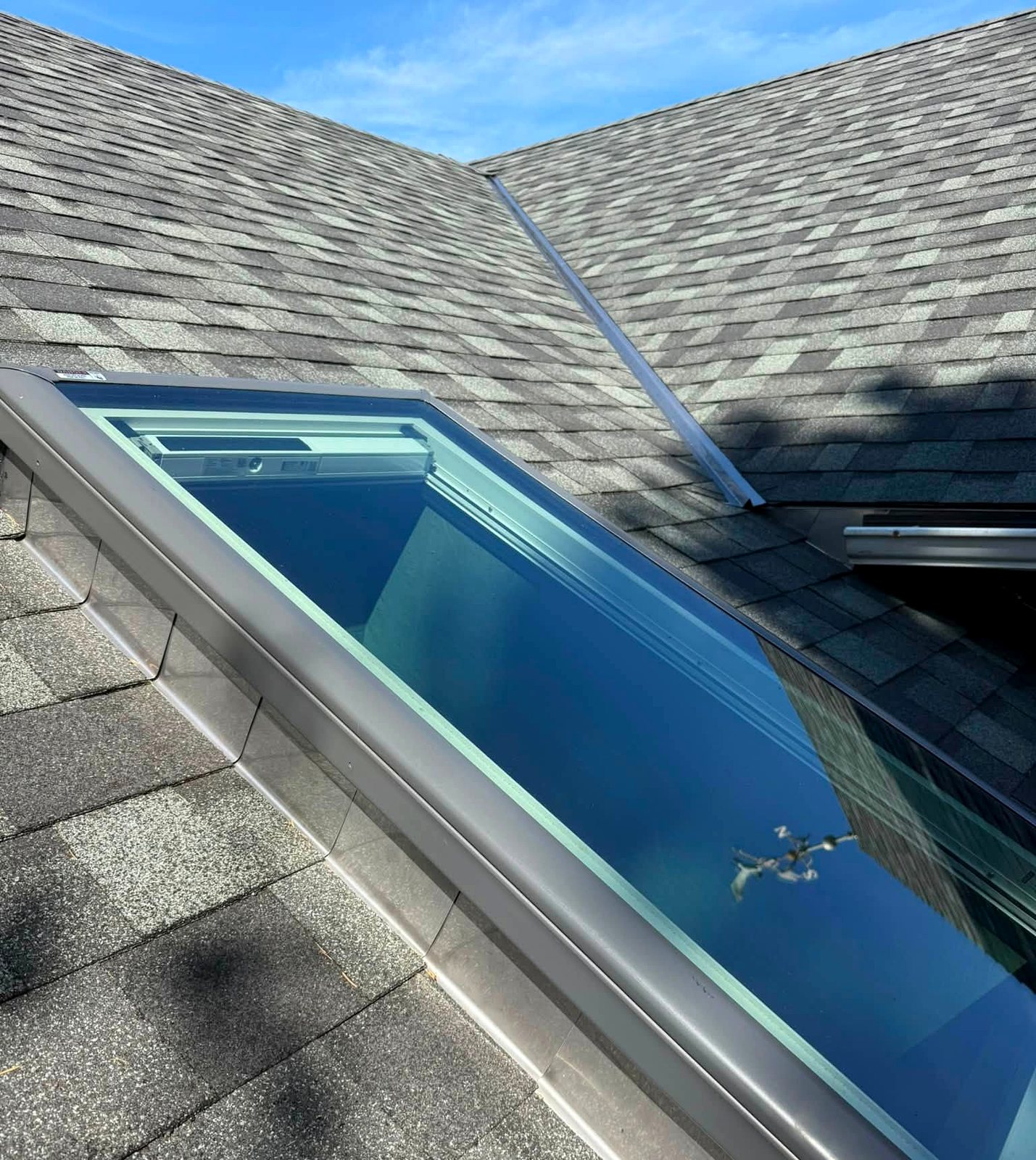A finished skylight installation with stainless flashing on an architectural shingle roof by Pacific Peaks Roofing